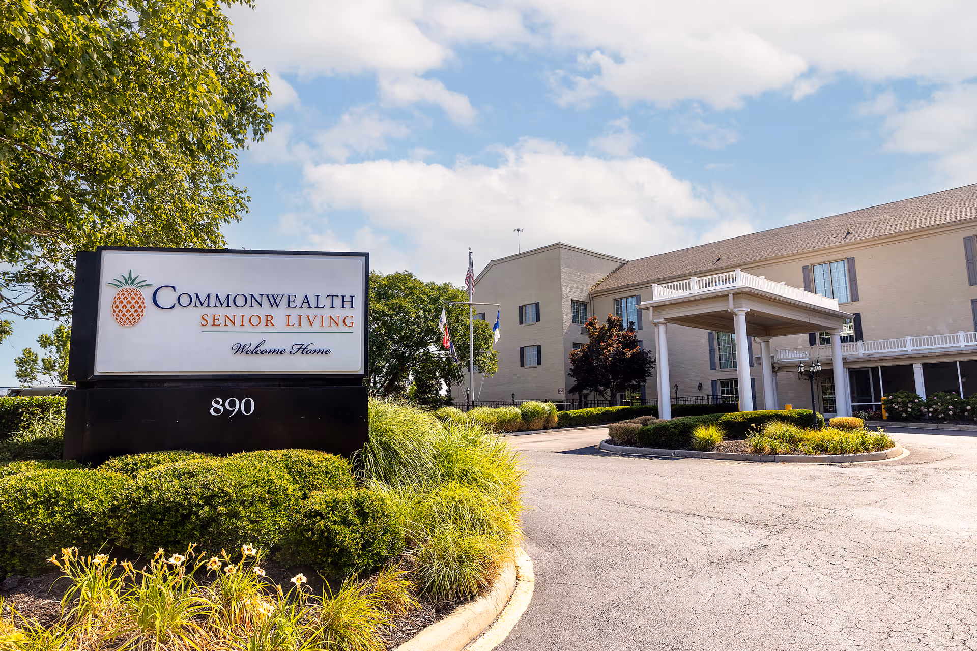 Exterior view of Commonwealth Senior Living at Leigh Hall with sign and entrance.
