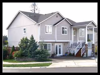 Two-story beige senior living facility with front entrance and stairs.