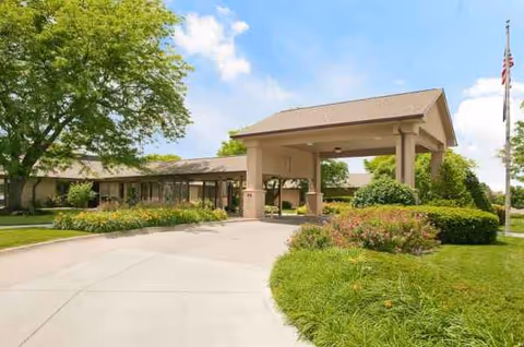 Exterior view of Life Care Center of Omaha entrance with driveway and landscaped grounds.