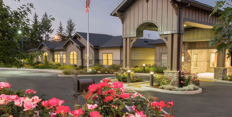 Exterior view of Windsong at Eola Hills entrance with landscaped flower beds.