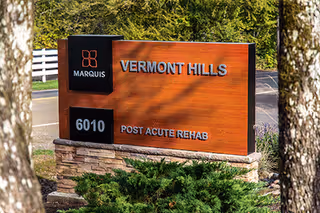 Outdoor Marquis Vermont Hills sign with brick base and landscaping.