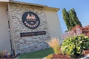Exterior view of Ponderosa Assisted Living sign on a stone-faced building.