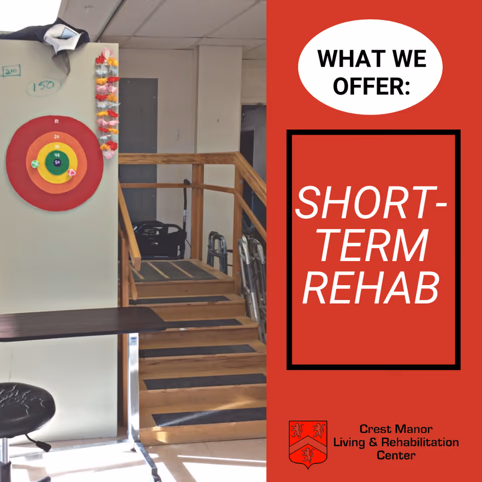 Interior view of a rehabilitation center room featuring a small staircase with wooden handrails, a target board on the wall with colored rings and attached balls, a black stool, and a table. On the right side, a red panel displays the text 'WHAT WE OFFER: SHORT-TERM REHAB' along with the Crest Manor Living & Rehabilitation Center logo and name.
