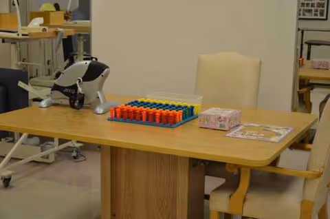 Colorful beads on a tray beside a medical device on a wooden table.