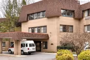 Exterior view of Autumn Lake Healthcare at Oakview entrance with a white van.