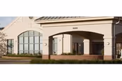 Exterior view of River Crossing of Rockford facility entrance with arches and shrubs.