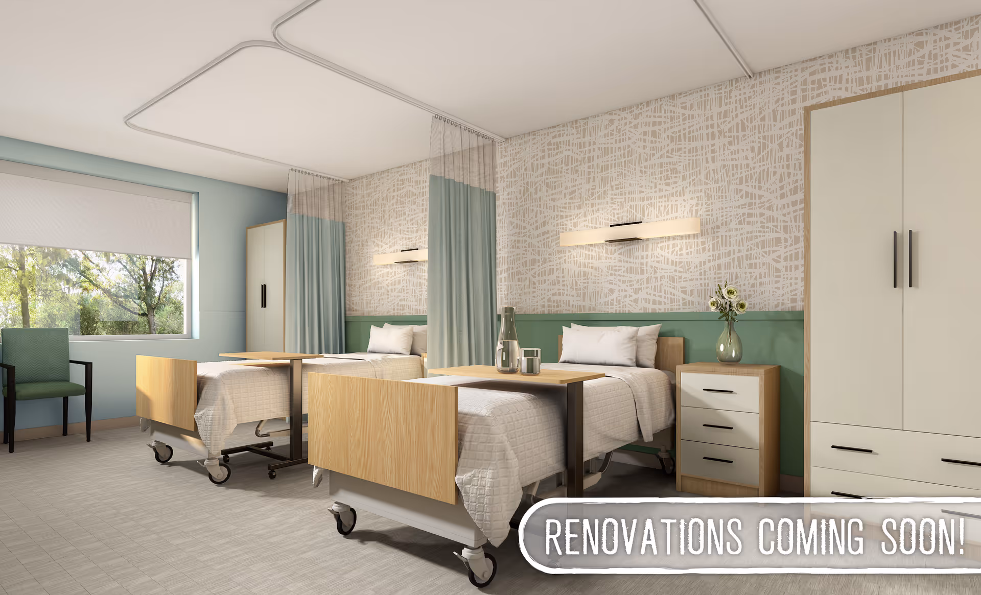 A bright and clean hospital-style room with two beds separated by a curtain. Each bed has a wooden headboard and footboard, white bedding, and an overbed table. There is a nightstand with a vase of flowers between the beds, a large wardrobe, and a green chair near a window showing trees outside. The walls have a green lower half and a patterned upper half, with modern wall lights above each bed. A banner at the bottom right corner reads 'RENOVATIONS COMING SOON!'