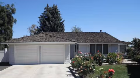 Single-story facility with a two-car garage, front driveway, and blooming rose bushes.