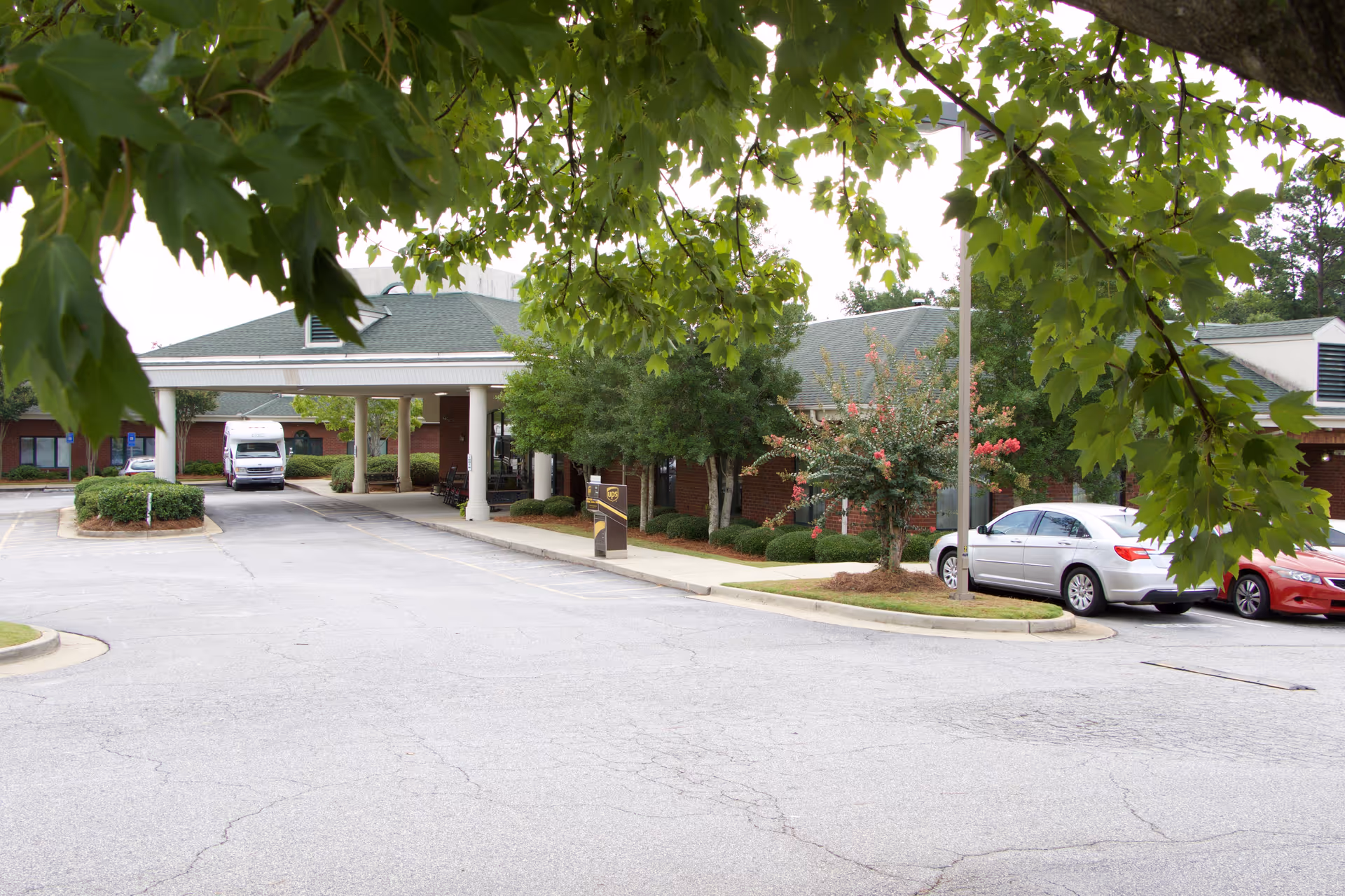 Exterior view of Magnolia Manor of Columbus Nursing Center entrance with cars