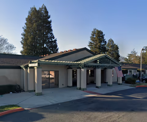 Exterior front view of a single-story senior living facility with a covered entrance.