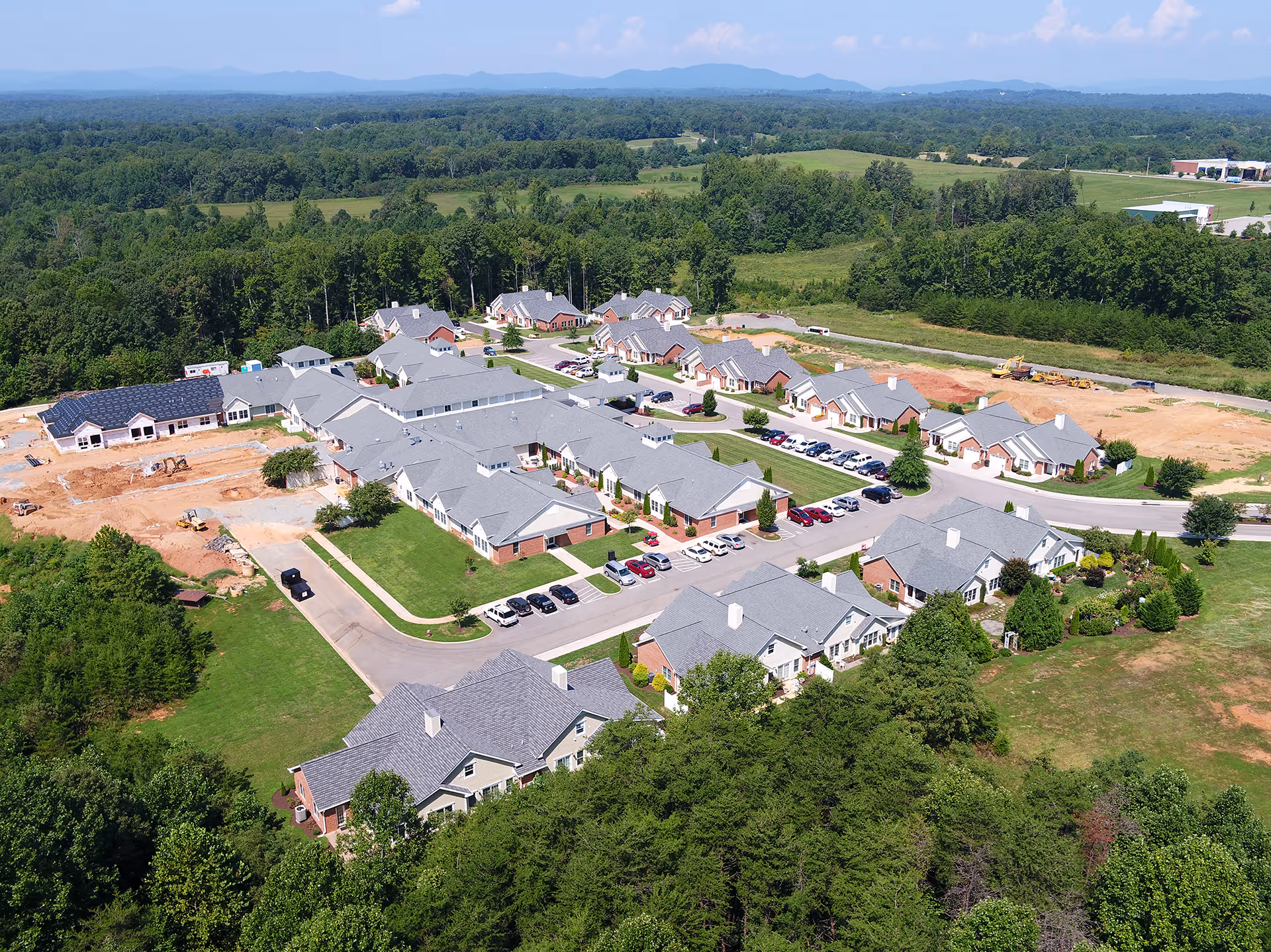This aerial view shows a senior living campus with gray-roofed residential buildings.
