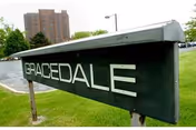 Outdoor sign for Gracedale Nursing Home on a grassy area with a building and trees in the background.