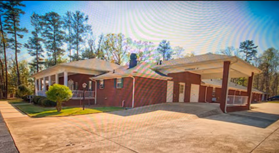 A single-story brick senior living facility with a covered entrance and driveway.