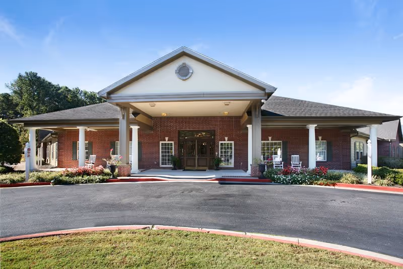 The Carriages of Marietta entrance: brick building with covered drop-off and landscaped front.