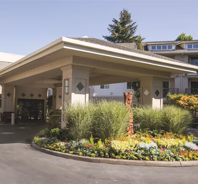 Exterior view of The Lakeshore entrance with landscaped circular driveway and canopy.
