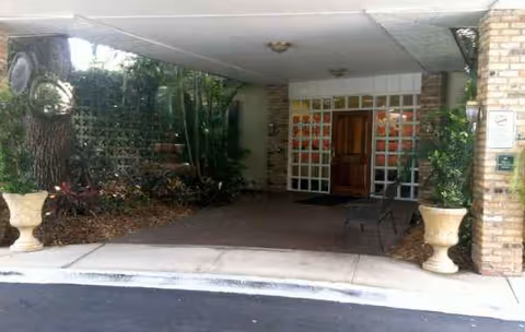 Exterior entrance of Grace Rehabilitation Center of Vero Beach with glass doors and planters.