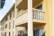 Exterior view of Campus Towers senior living building with yellow walls and balconies.