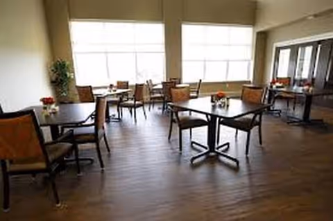 Heritage Manor dining room with multiple tables and chairs in a bright setting.