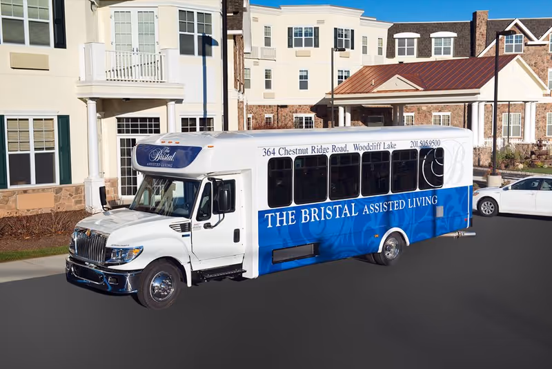 The Bristal Assisted Living bus parked in front of a modern senior living building.