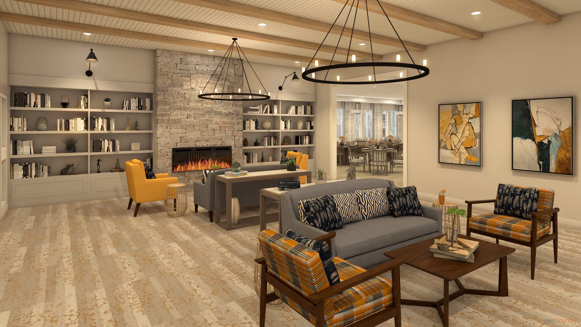A cozy senior living facility common area with a modern stone fireplace, built-in bookshelves filled with books and decor, a gray sofa with patterned pillows, two orange and blue plaid armchairs, a wooden coffee table with books and a plant, and two large circular chandeliers hanging from a ceiling with wooden beams. In the background, a dining area with tables and chairs is visible through an open doorway. The walls are decorated with abstract paintings.