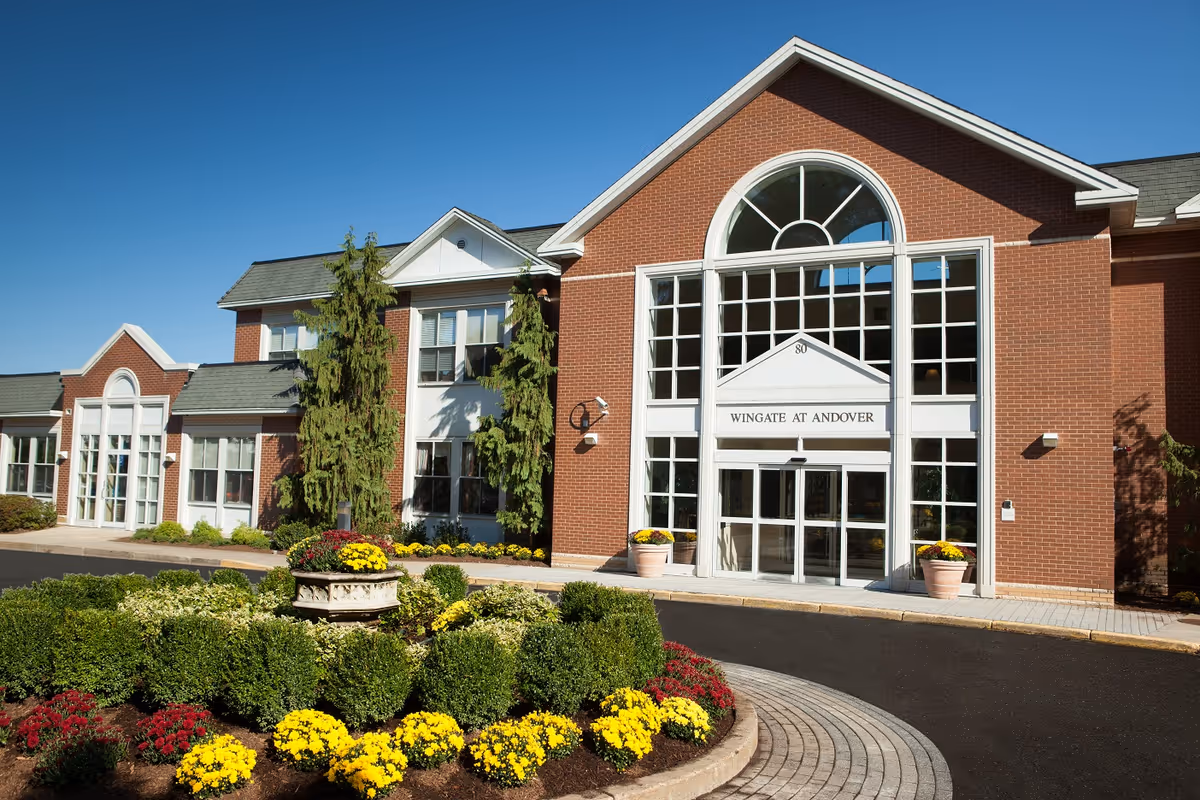 Bear Mountain at Andover facility entrance with arched windows and manicured flowerbeds.