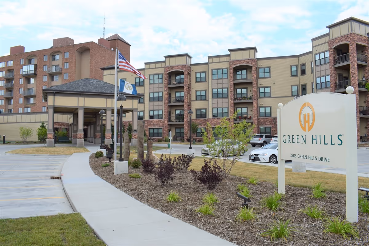 Exterior view of Green Hills senior living community with entrance and signage.