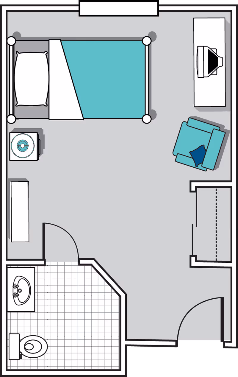 Floor plan of a single room featuring a bed with a pillow and blanket, a nightstand with a lamp, a chair with a cushion, a dresser with a TV on top, a closet, and an attached bathroom with a sink and toilet.
