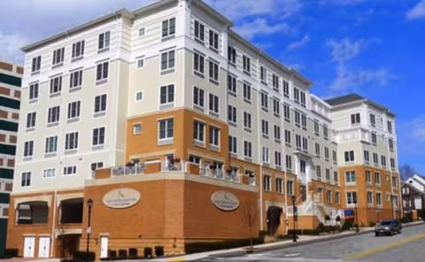 A multi-story Willow Towers senior living building with beige and orange brick facade.