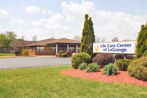 Front exterior of Life Care Center of LaGrange with landscaped shrubs and sign.