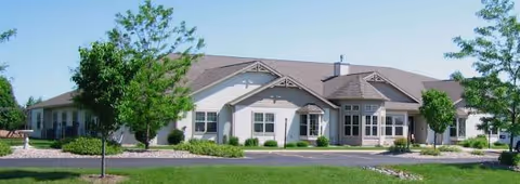 This is the front exterior of a single-story assisted living facility with manicured landscaping.