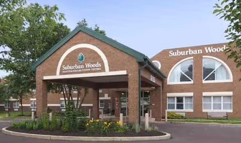 Brick facility exterior with Suburban Woods entrance, signage, and landscaped front yard.
