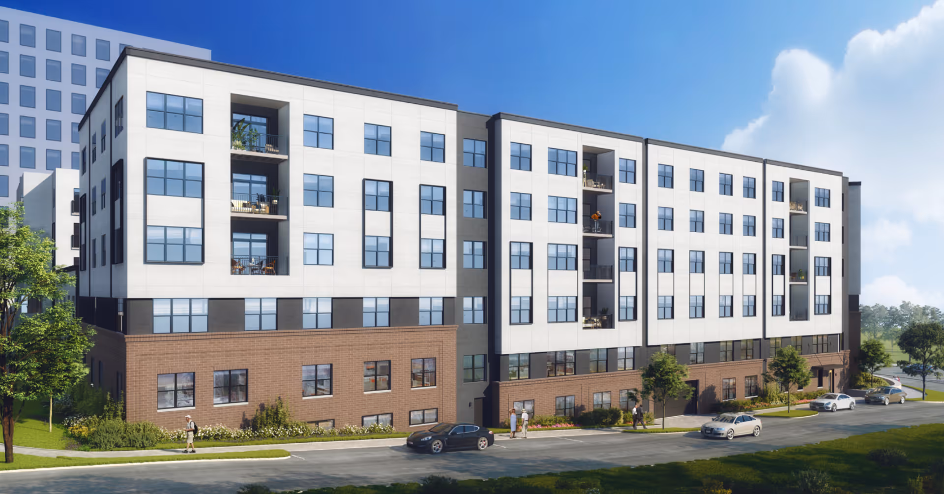 Modern five-story senior living building with a brick lower level, white upper facade, balconies, landscaping and cars along the street.