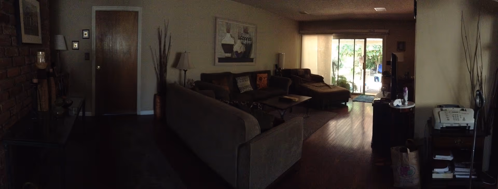 Spacious living room with sofas, a coffee table, TV and sliding glass doors opening to a patio.