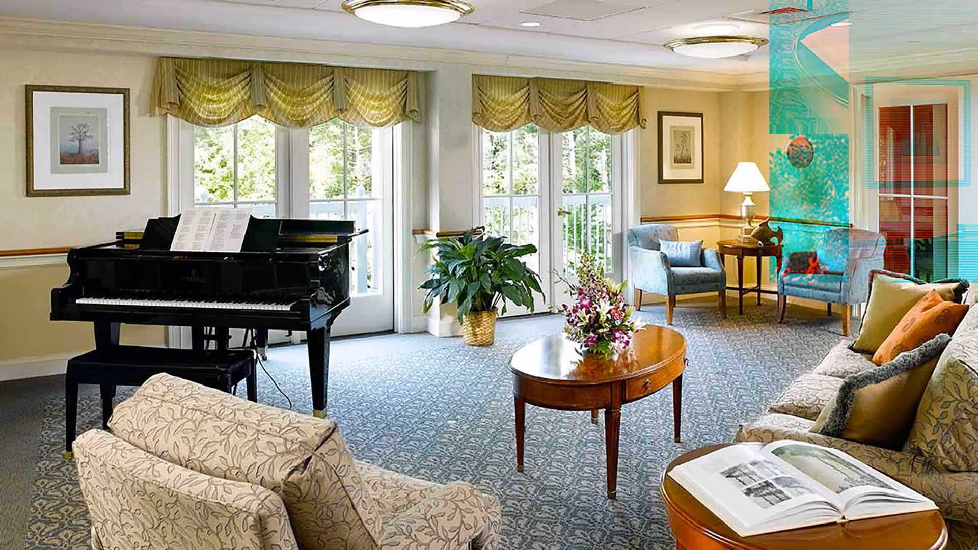 Bright common living room with a grand piano, seating area, coffee table with flowers, and large windows.