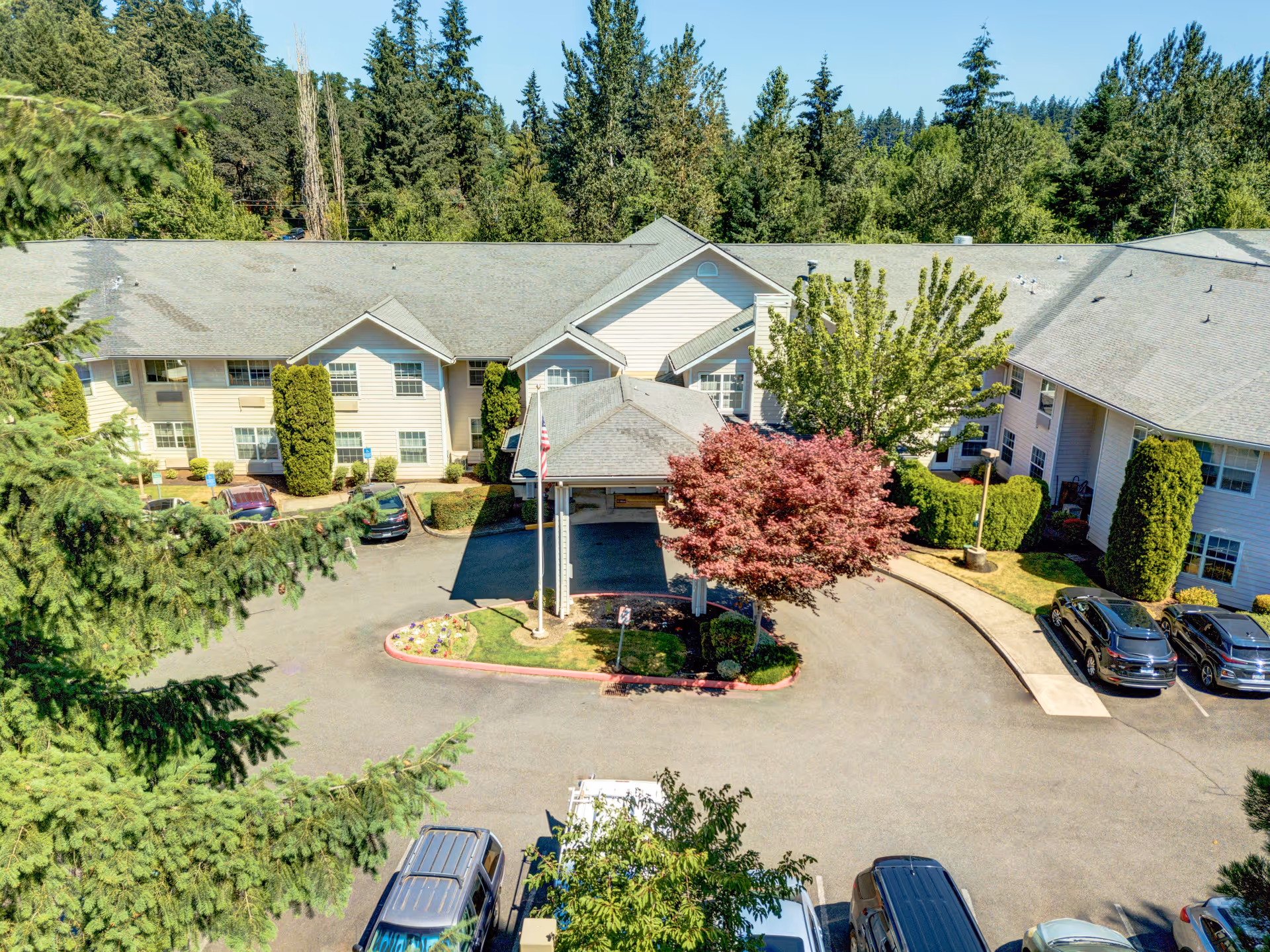 Aerial view of Redwood Heights by Cogir exterior with driveway and parked cars.