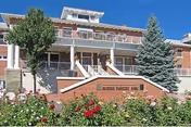 Exterior view of Arizona Pioneers' Home with brick façade, stairs, and blooming garden.