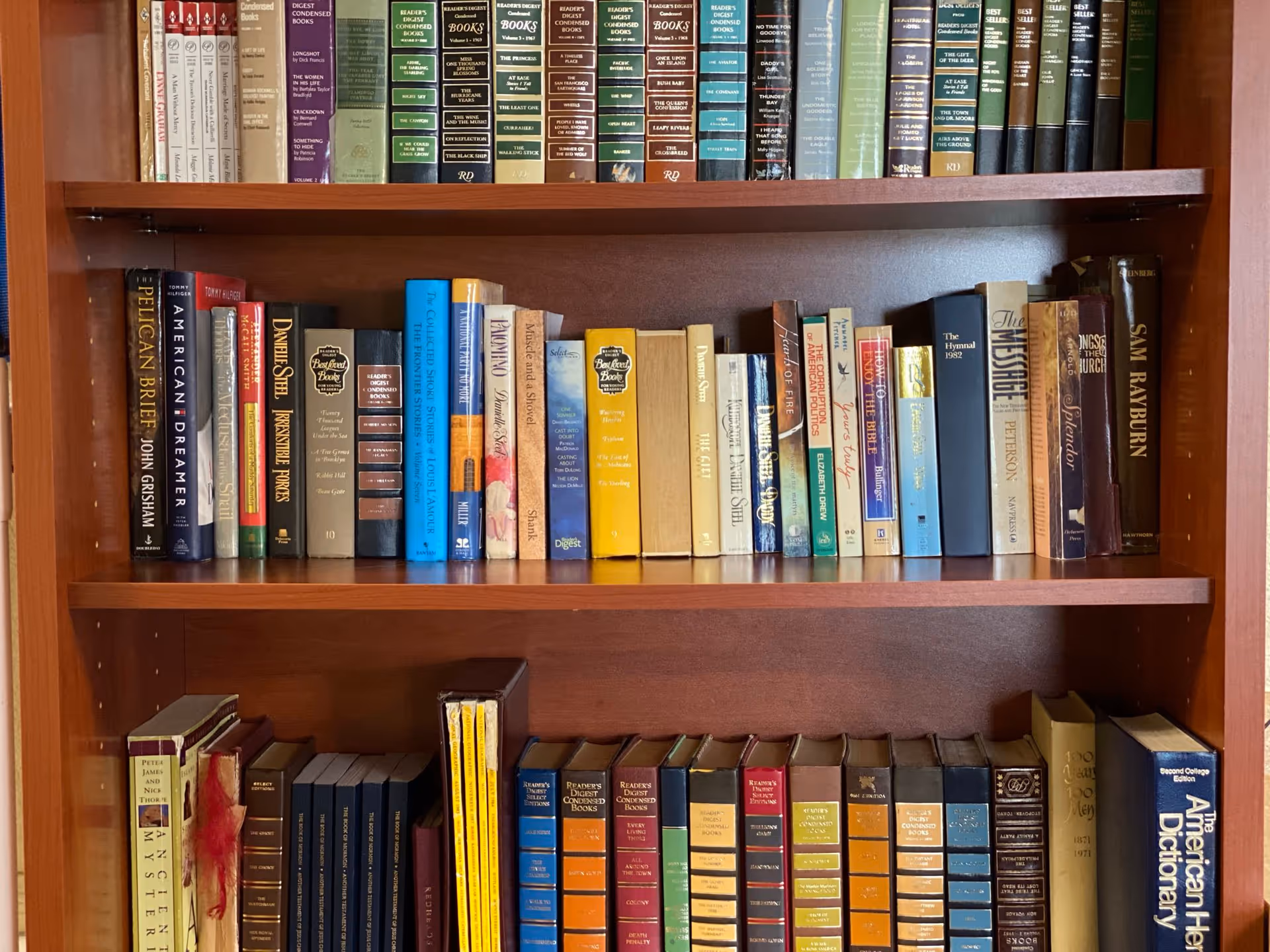 Wooden bookshelf filled with rows of assorted books arranged on multiple shelves.