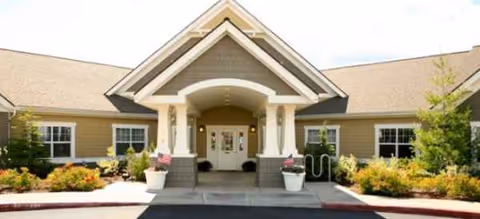 Front entrance of a Brookdale Bend senior living facility with a covered doorway and landscaping.
