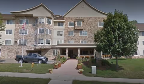 Exterior view of Cannon Rivers Senior Living building with entrance walkway and landscaping.