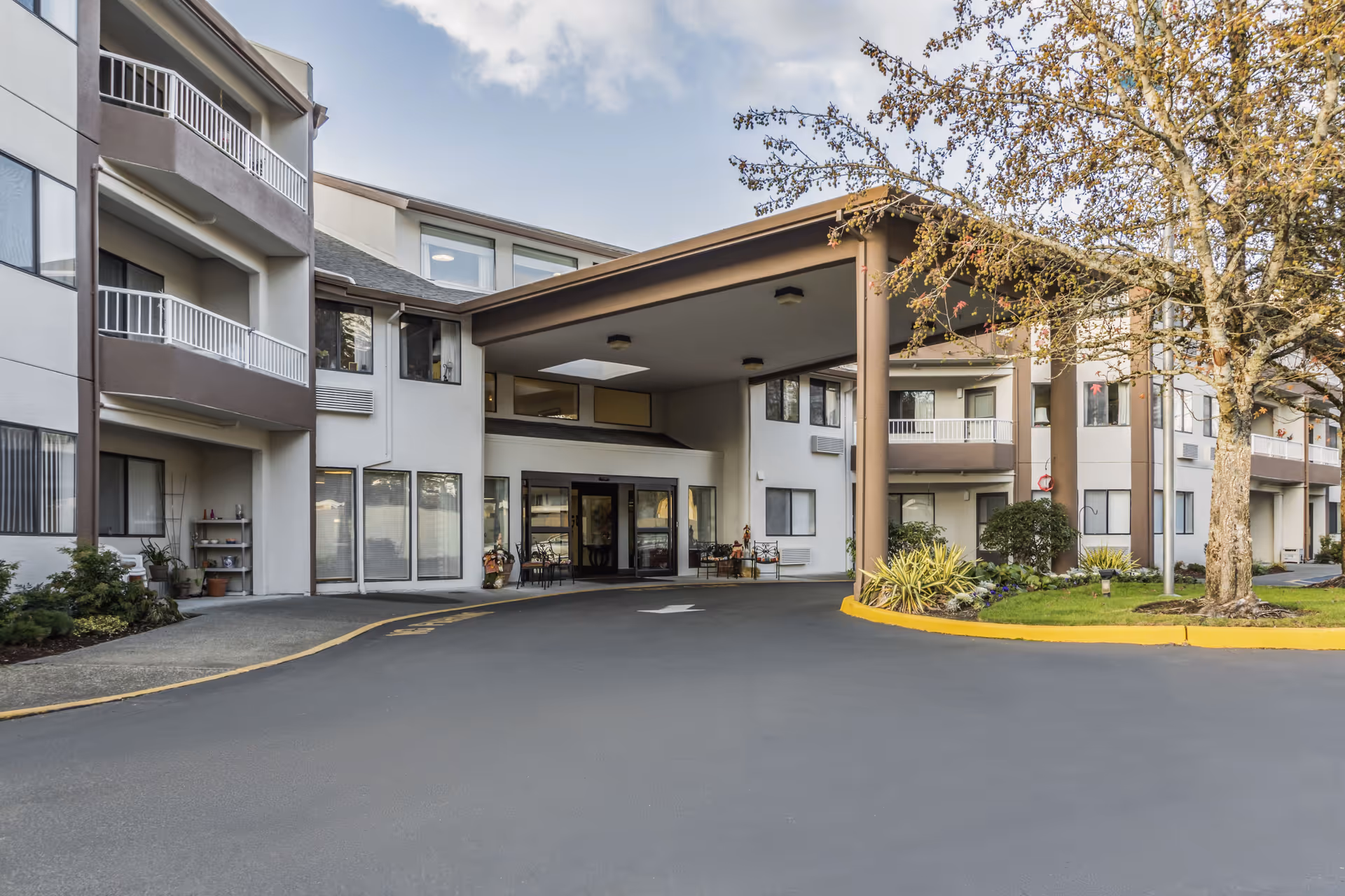Exterior view of Capital Place Retirement Community with covered entrance and circular driveway.