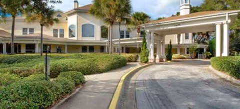 Exterior view of Colliers Assisted Living at Port Orange with a covered entrance driveway.