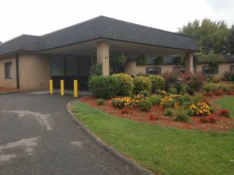 Exterior view of Lincolnton Rehabilitation Center with entrance, landscaping, and driveway.
