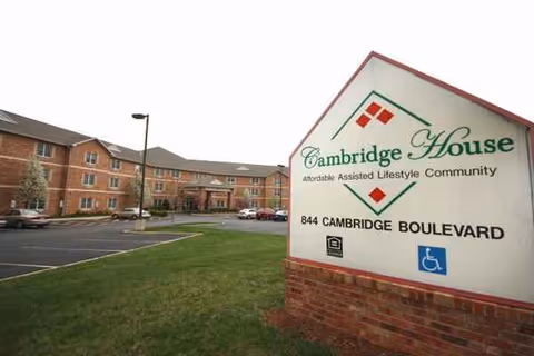 Exterior view of Cambridge House of Ofallon with sign and parking lot.