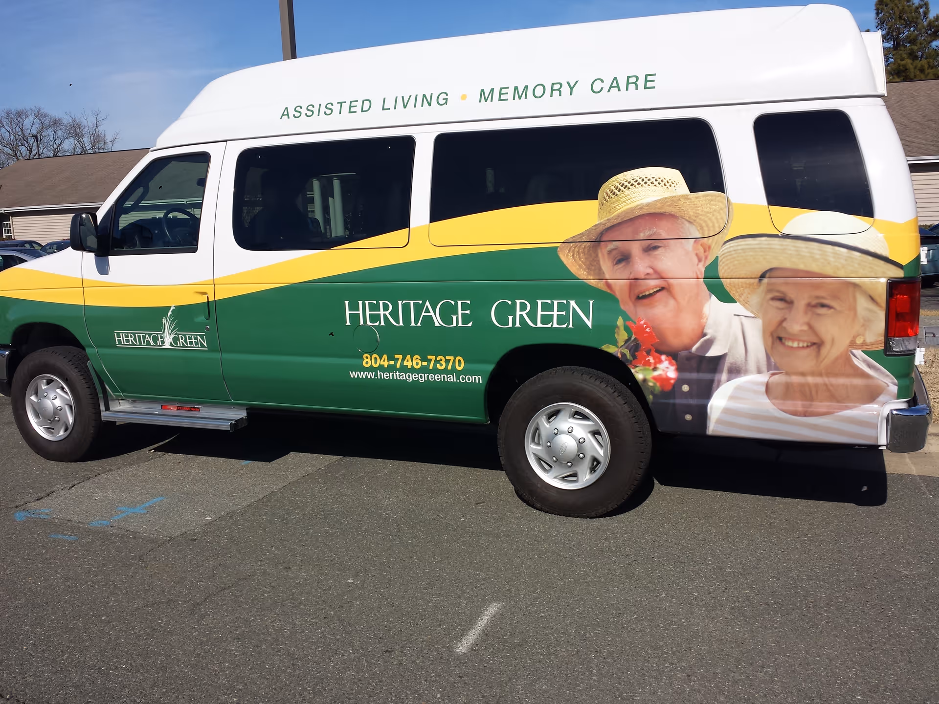 A Heritage Green assisted living shuttle van parked outside with large photos of smiling elderly people and facility branding.