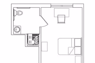 Floor plan of a small living space featuring a bedroom area with a bed and a chair, a bathroom with a toilet and sink, and a small kitchenette with a sink.