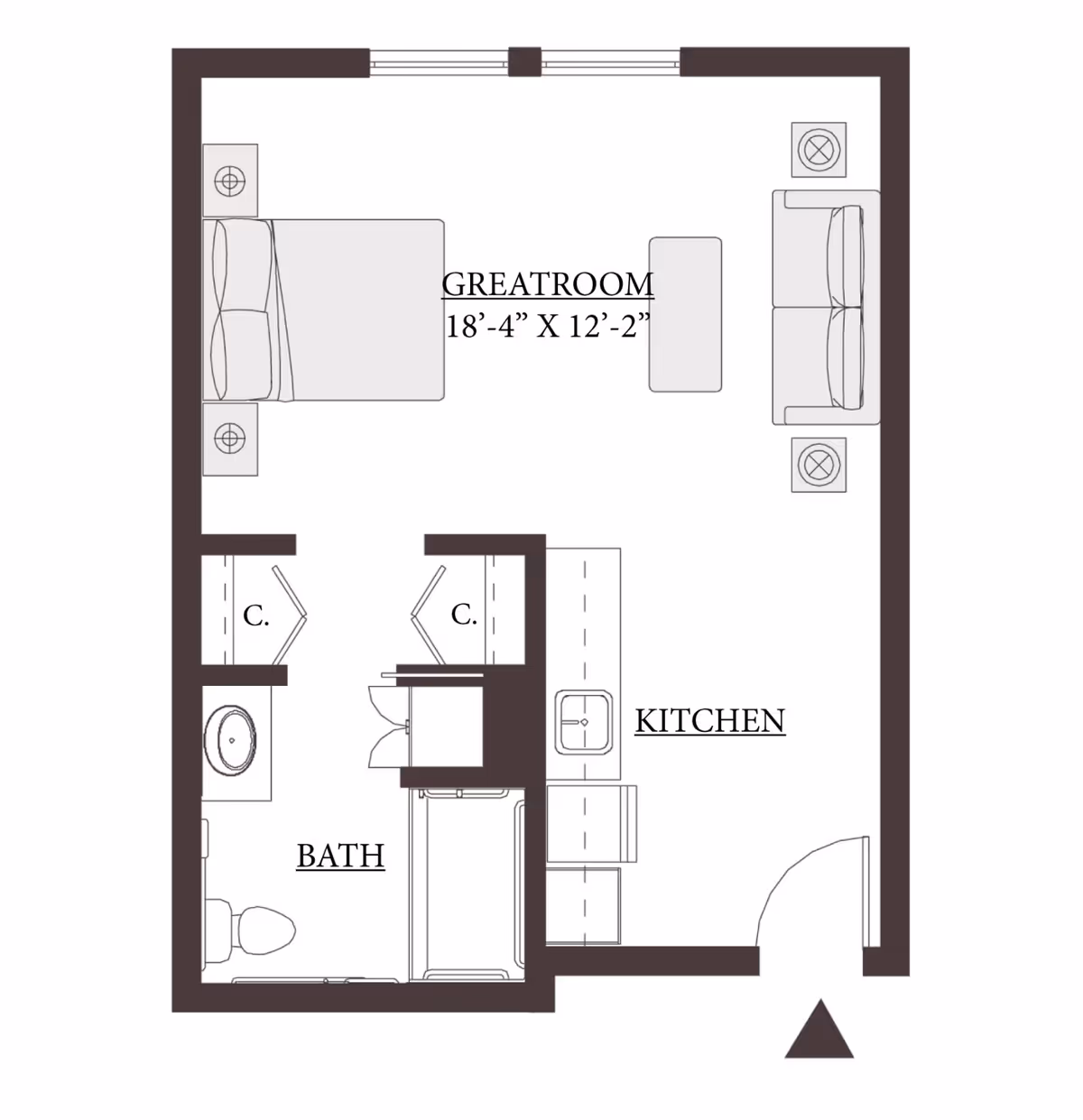Floor plan of a studio apartment at The Springs at Bozeman showing a great room with a bed, sofa, and coffee table, a kitchen area with a sink and counter, and a bathroom with a toilet, sink, and shower. Two closets are located near the bathroom.
