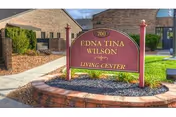Front view of a sign reading Edna Tina Wilson Living Center outside a brick building