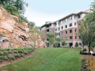 Exterior view of Cedar Crest with a multi-story brick building and landscaped lawn.