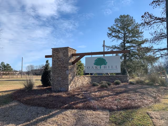 Exterior view of Oak Hill entrance sign with stone pillars and landscaping.