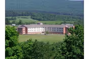 Exterior view of Meadow View Nursing Center on a grassy hillside.